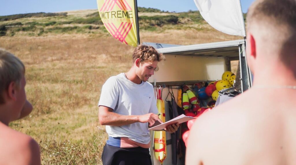 Coasteering guide leading safety briefing for group at Baggy Point